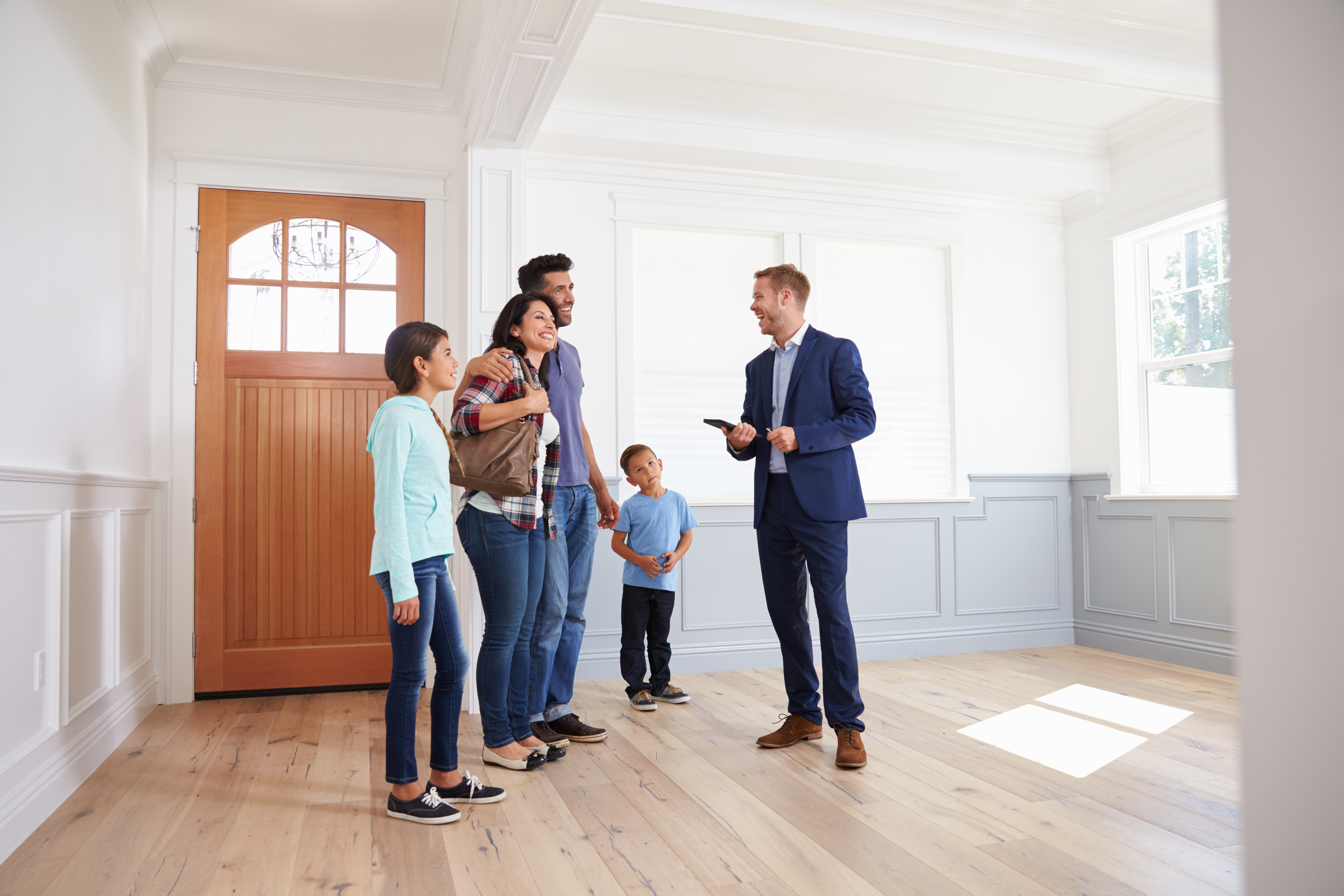 Family looking at home with real estate agent.